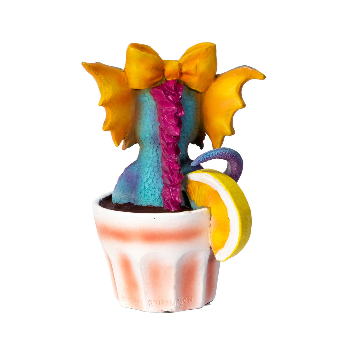 Colorful blue, pink and orange dragon figurine in a glass with lemon wedge