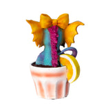 Colorful blue, pink and orange dragon figurine in a glass with lemon wedge