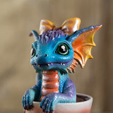 Colorful dragon figurine with orange bow sitting in a glass