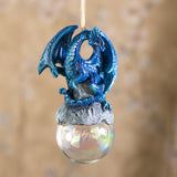 Ornament with blue dragon on rocks on iridescent glass bubble