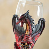 Closeup of red and black dragon holding sword, glass goblet