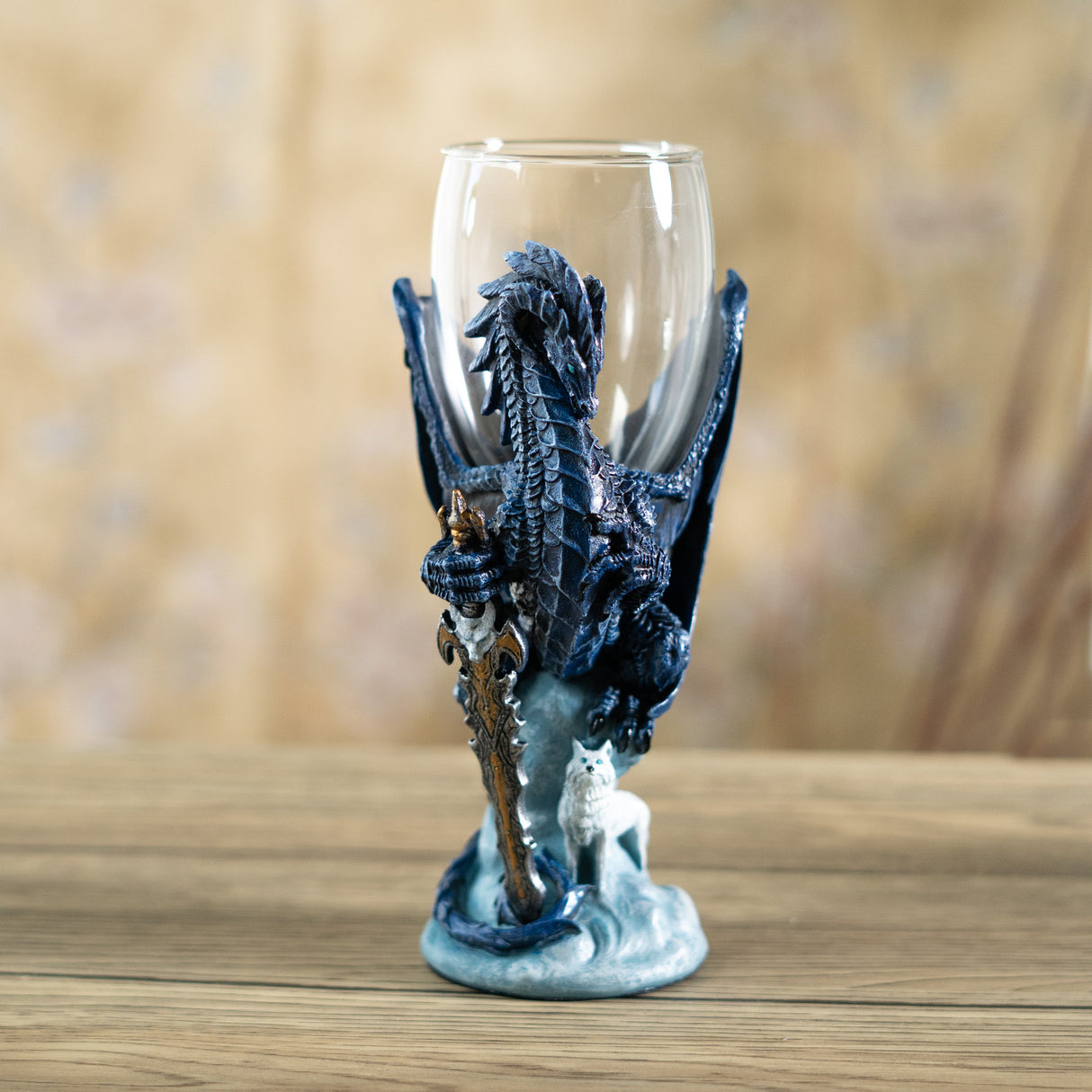 Glass goblet with blue dragon holding sword with white wolf