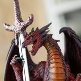Closeup of red, orange and black dragon with letter opener sword