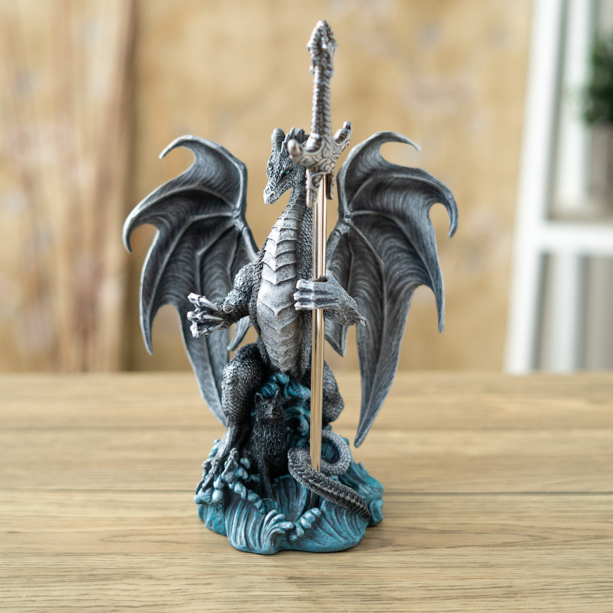 Gray dragon with wolf in the waves, holding a sword letter opener
