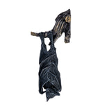 Decorative wall plaque of a black bat hanging upside down