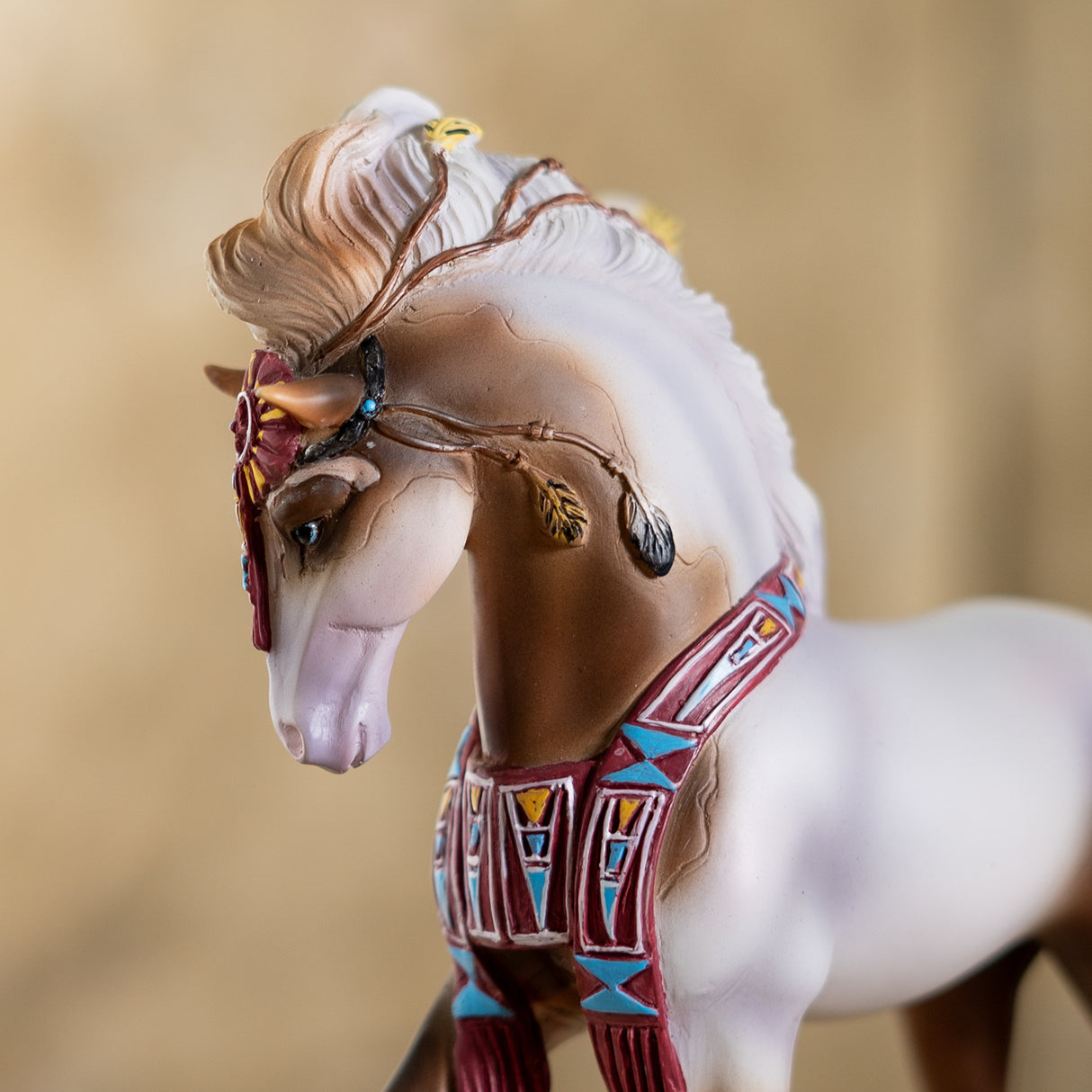Closeup of horse figurine, brown and white pinto with southwestern accents and feathers