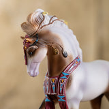 Closeup of horse figurine, brown and white pinto with southwestern accents and feathers