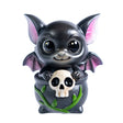 Small figurine of a black dragon imp with pink accents sitting in a cauldron with vines and a skull