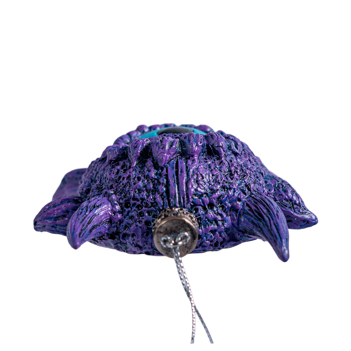 Ornament of a blue eye surrounded by purple scales and horns, shown top down