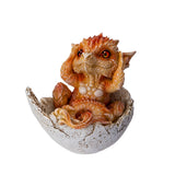 Small orange dragon figurine emerging from a cracked eggshell