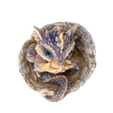Dragon figurine hatching from an egg, shown top down