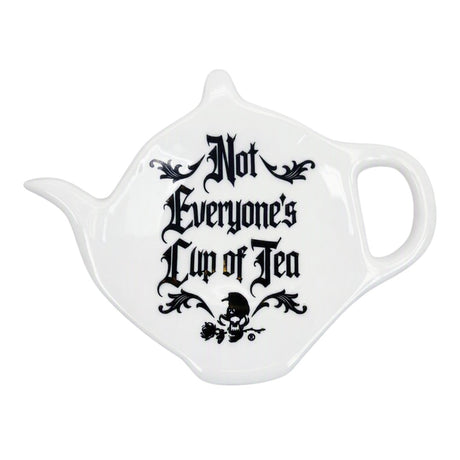 A white ceramic teapot-shaped spoon rest with the phrase 'Not Everyone's Cup of Tea' printed in black gothic lettering and a small skull graphic, shown on a plain white background.