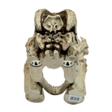 A dinosaur skeleton head toilet paper holder - shown from the back with mounting holes