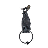 A black bat door knocker featuring a detailed bat sculpture hanging from a branch, with a circular ring at the bottom, shown against a plain white background.
