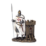 A medieval Templar knight figurine in chainmail and white surcoat with a red cross, holding a spear next to a small stone castle tower  that doubles as a utility desk caddy/pen holder