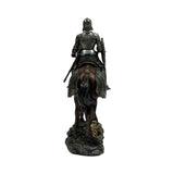 A detailed equestrian statue of a knight in full armor riding a horse, shown from behind