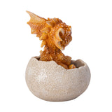 A small orange-brown dragon figurine peeking out of a cracked beige egg, shown from the back
