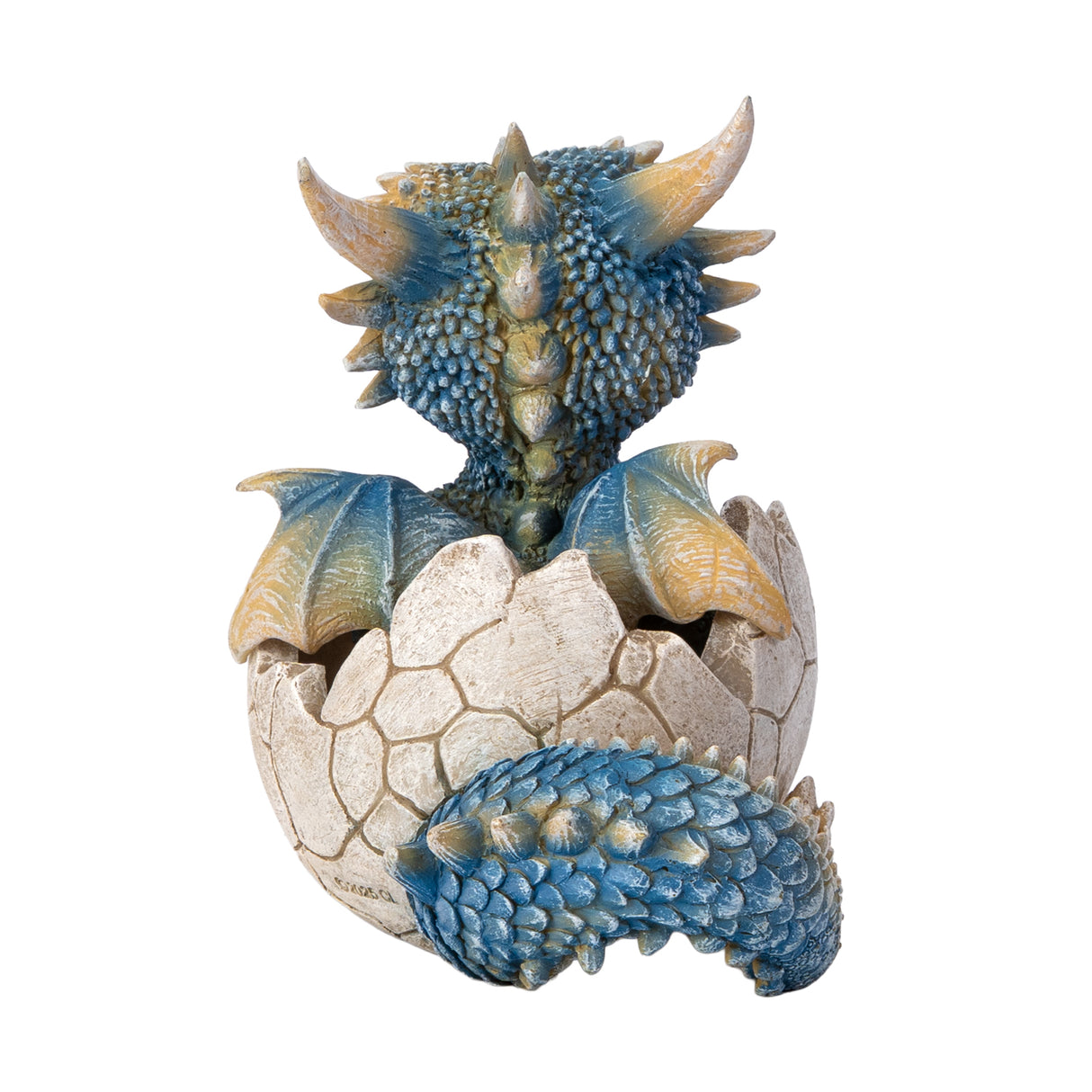 A small fantasy dragon figurine peeking out of a cracked eggshell, shown on a plain white background. The dragon has tan and blue scales, large bright blue eyes, black claws, and small wings. Shown from the back