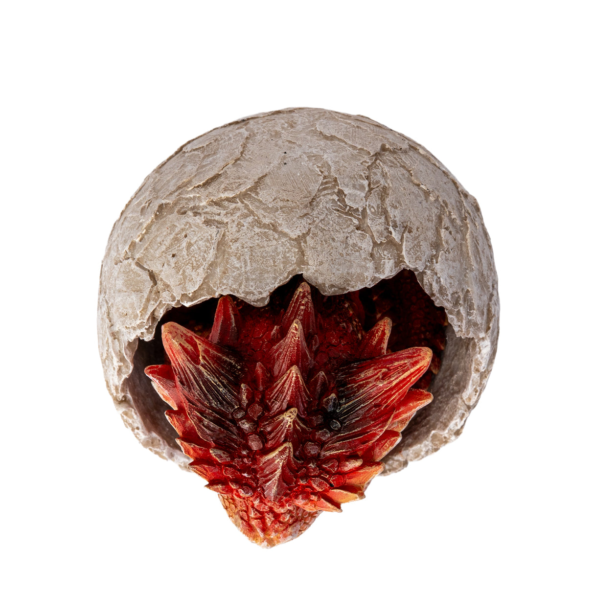 A small red dragon figurine sitting inside a cracked stone egg, shown top down