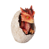 A small red dragon figurine sitting inside a cracked stone egg