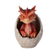 A small red dragon figurine sitting inside a cracked stone egg