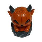 Orange pumpkin-head imp in a black cauldron with moons, shown top down