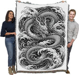 Tapestry blanket in black and white with water dragon, held by two adults
