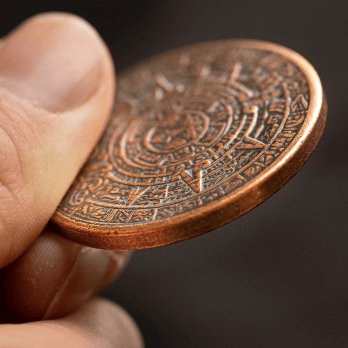 Aztec calendar coin thickness, shown held, copper