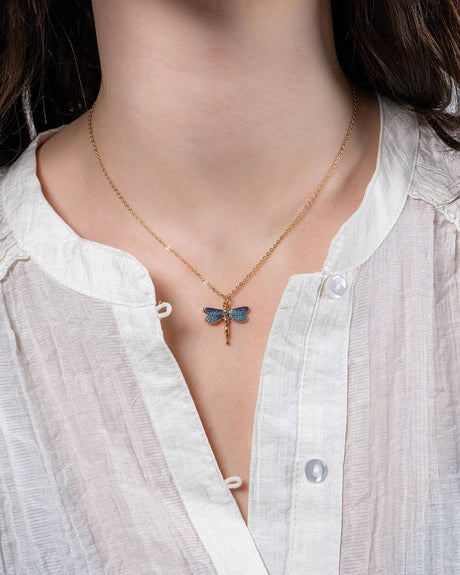 Necklace with a blue butterfly pendant worn by a person in a white shirt.