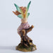 Figurine of a fairy leaning towards the butterfly on her hands. Red hair, green tipped wings, pink dress, sitting on a tree stump. Back view