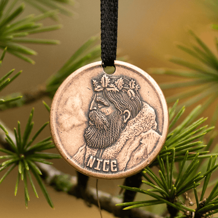Naughty or Nice Ornament with Santa on one side, shown hung in a tree