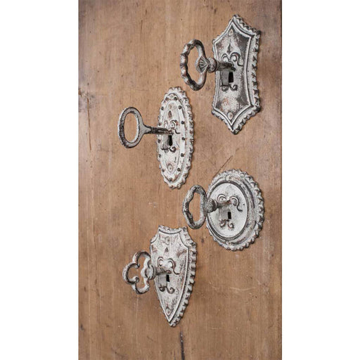 Wall hooks shaped like antique metal keys in locks. Set of four, shown on a wood wall