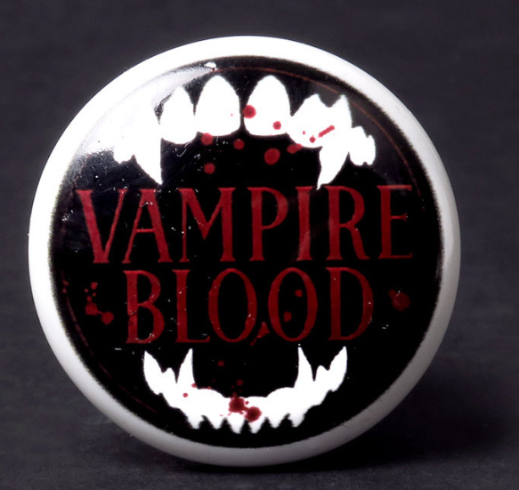 Bottle stopper with fangs and text "VAMPIRE BLOOD"