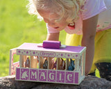Breyer toy horse carrier with unicorn figurines, "MAGIC" written across the front, pink on wood, shown with a little girl