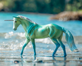 Model unicorn in shades of blue and white with silver, shown posed on a beach