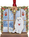 Brass ornament of a white cat sitting in a festive windowsill with snow beyond and a snow globe.