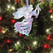 Metal ornament of an angel wearing a swirl patterned dress of pink and blue, shown on a tree