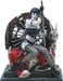Figurine of a pale woman with black hair, outfit and fishnets sitting on a throne of skulls and red fabric, holding a sword