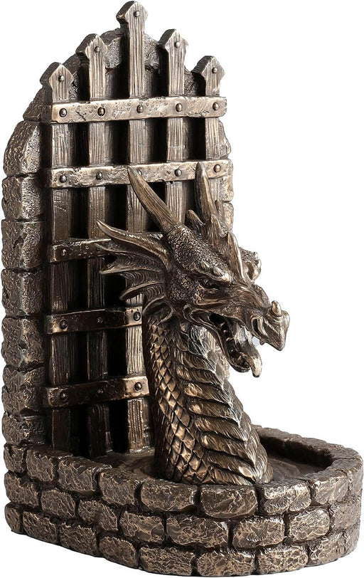Bronze colored bookend with dragon head in front of a portcullis