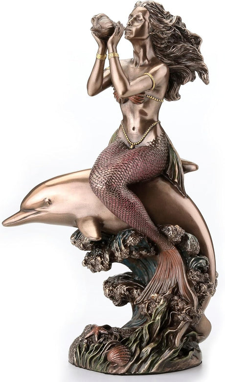 Bronze-hued mermaid on the back of a dolphin blowing into shell figurine