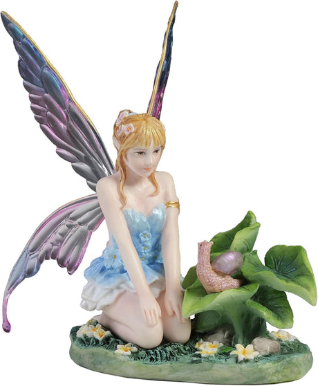 Blond fairy figurine with colorful wings sitting on flowers and grass with a snail on a leaf next to her