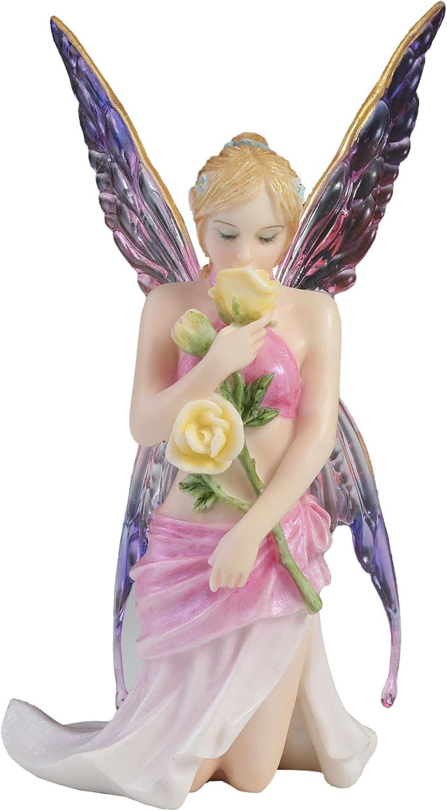 Fairy figurine with pink dress and purple wings holding flowers on a white background