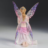 Fairy figurine with colorful wings on a gradient background