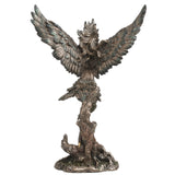 Statue of a feather winged harpy woman on a tree stump with talon feet, shown from the back