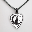 Guitar pick-shaped pendant with a black cat design on a white background