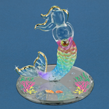 Glass mermaid figurine with rainbow tail, gold accents, holding crystal on mirrored base