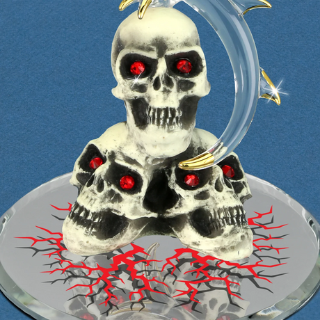 Closeup of glass stack of three red-eyed skulls on mirrored base