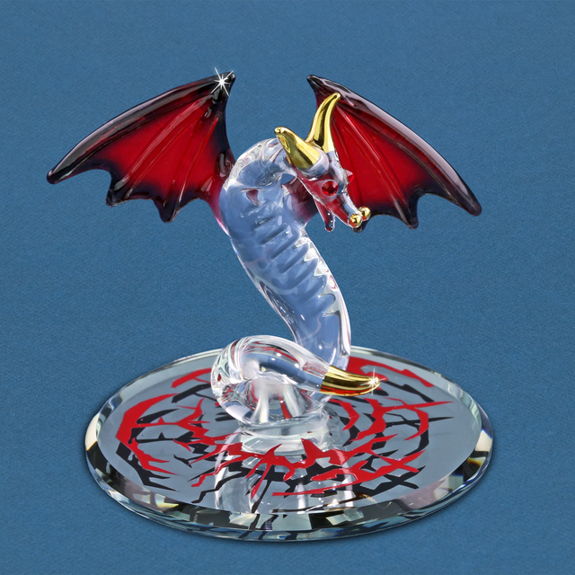 Glass dragon figurine with red eyes, red and black wings, gold accents sitting on a decorated mirror base