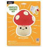 Crochet kit packaging for a mushroom with red cap and beige body on an orange background.