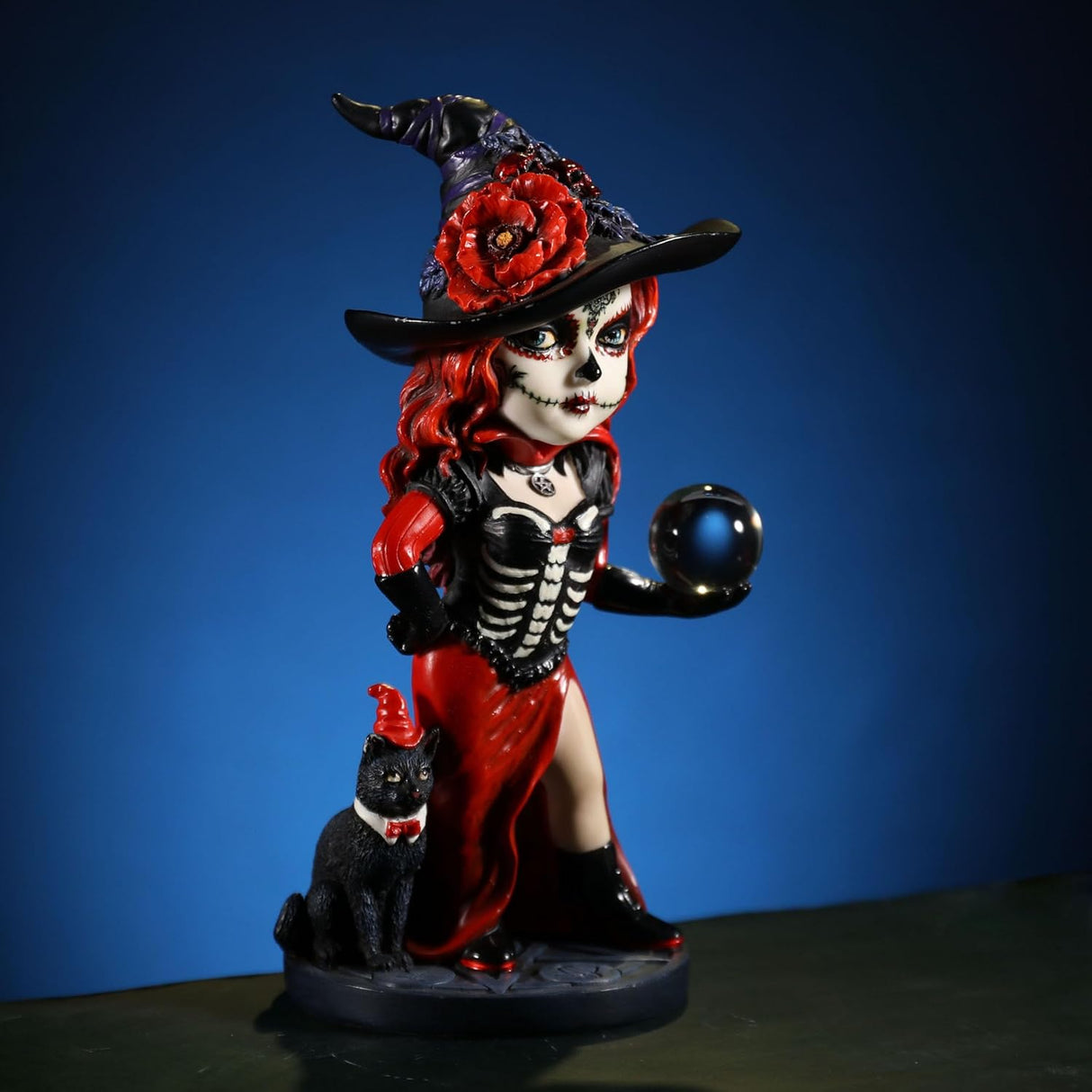 Figurine of witch in red and black with cat and crystal ball, Day of the Dead face paint